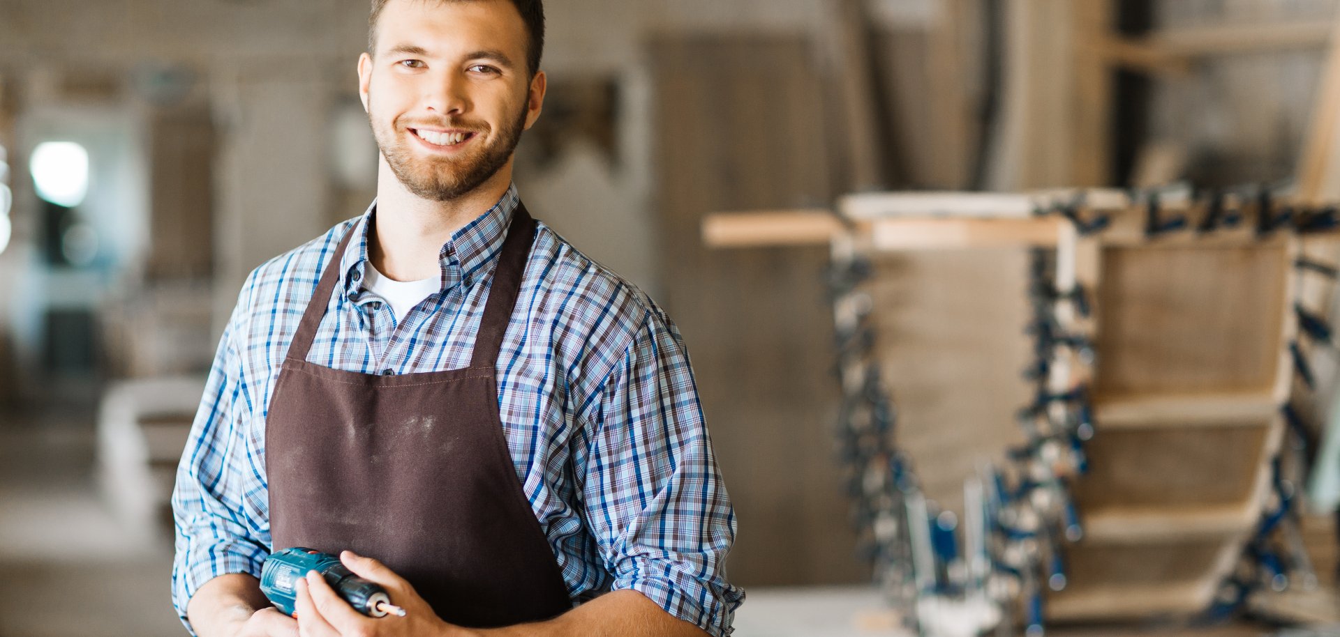 Smiling craftsman with electric drill